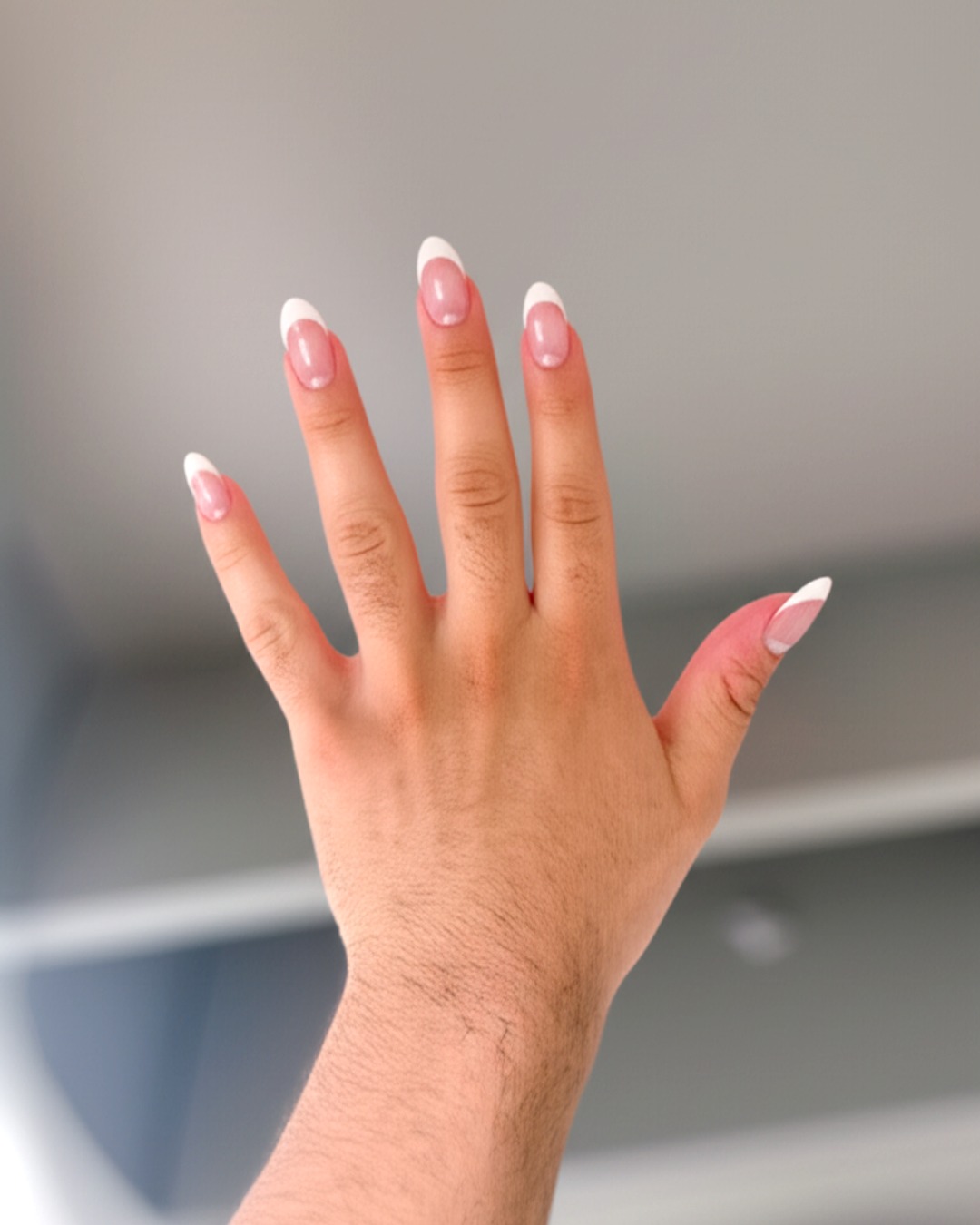 white french tip nails with natural base, almond shape, medium length, glossy finish