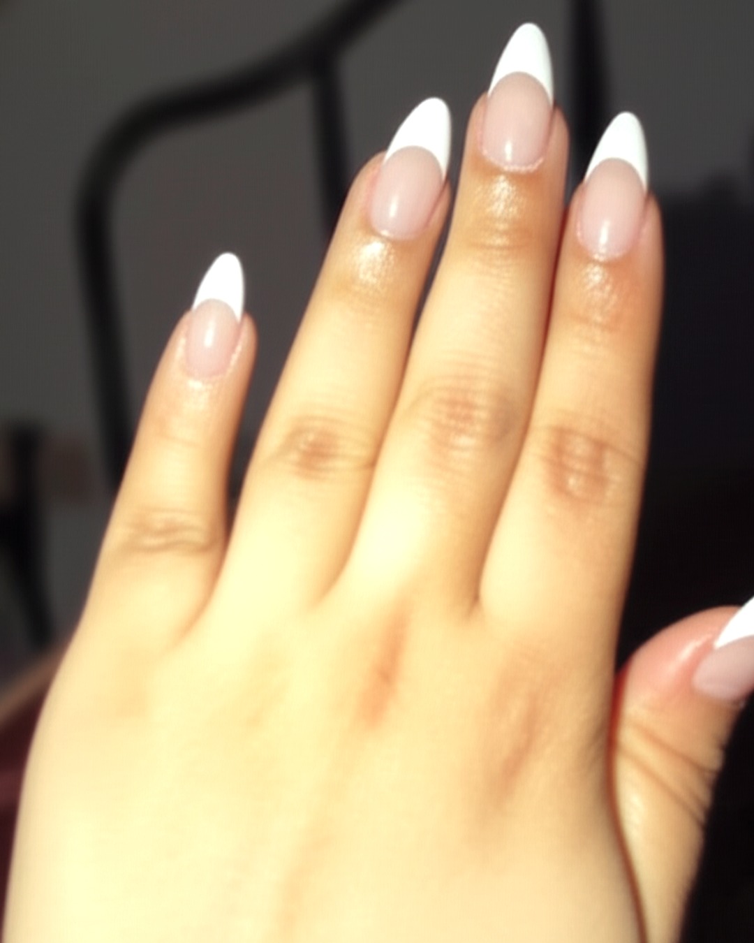 white french tip nails with natural base, stiletto shape, medium length, pearlescent finish