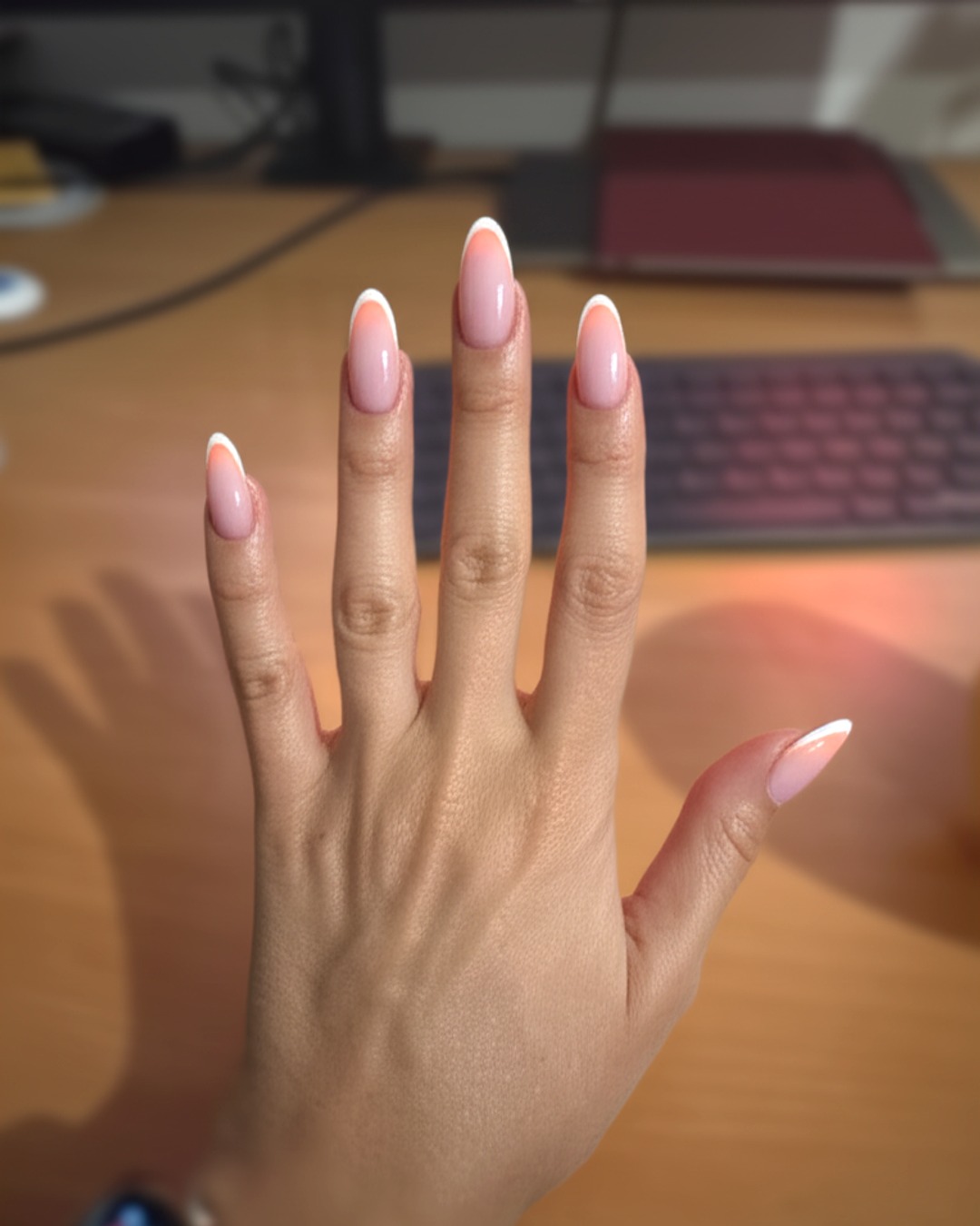 peach french tip nails with natural base, almond shape, medium length, glossy finish